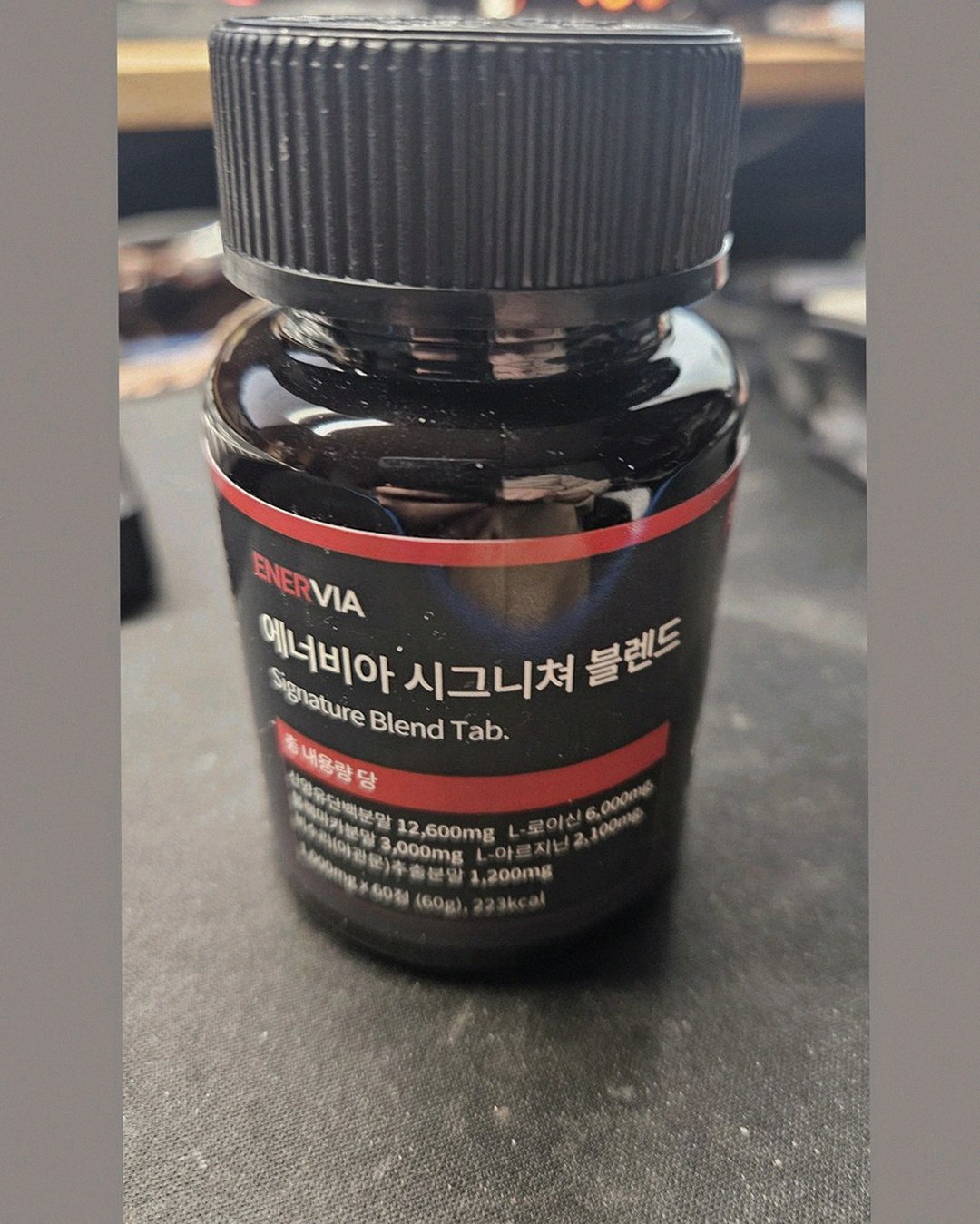enervia 2.0 bottle on office desk with water glass