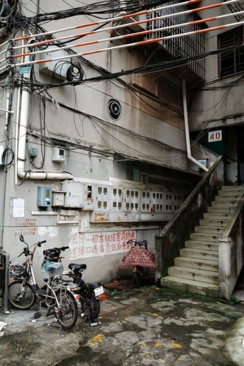 광저우 주택가 골목의 낡은 건물과 오토바이, 도시의 로컬 분위기를 느낄 수 있는 일상적인 거리 풍경