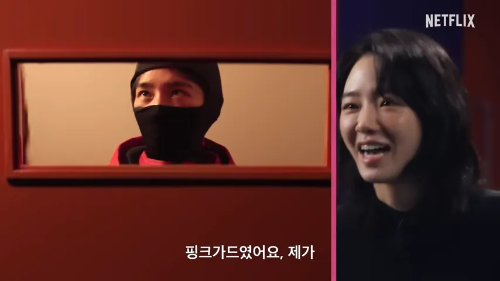 오징어 게임’ 관련 의상을 입은 배우 이진욱의 모습으로, 핑크 가드 복장에 대한 궁금증을 자아내는 장면