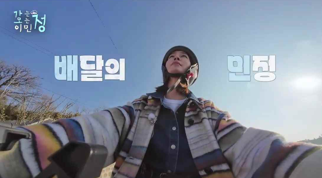 이민정이 전기자전거를 타고 배달가는 장면에 배달의 민정 자막이 있는 스틸컷