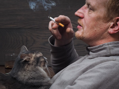 고양이 눈 앞에서 담배를 피우는 남자.