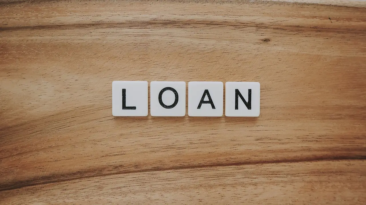 신용점수- 나무판자 위 흰색 정육각형 4개 윗면에 각각 검정 글씨 LOAN