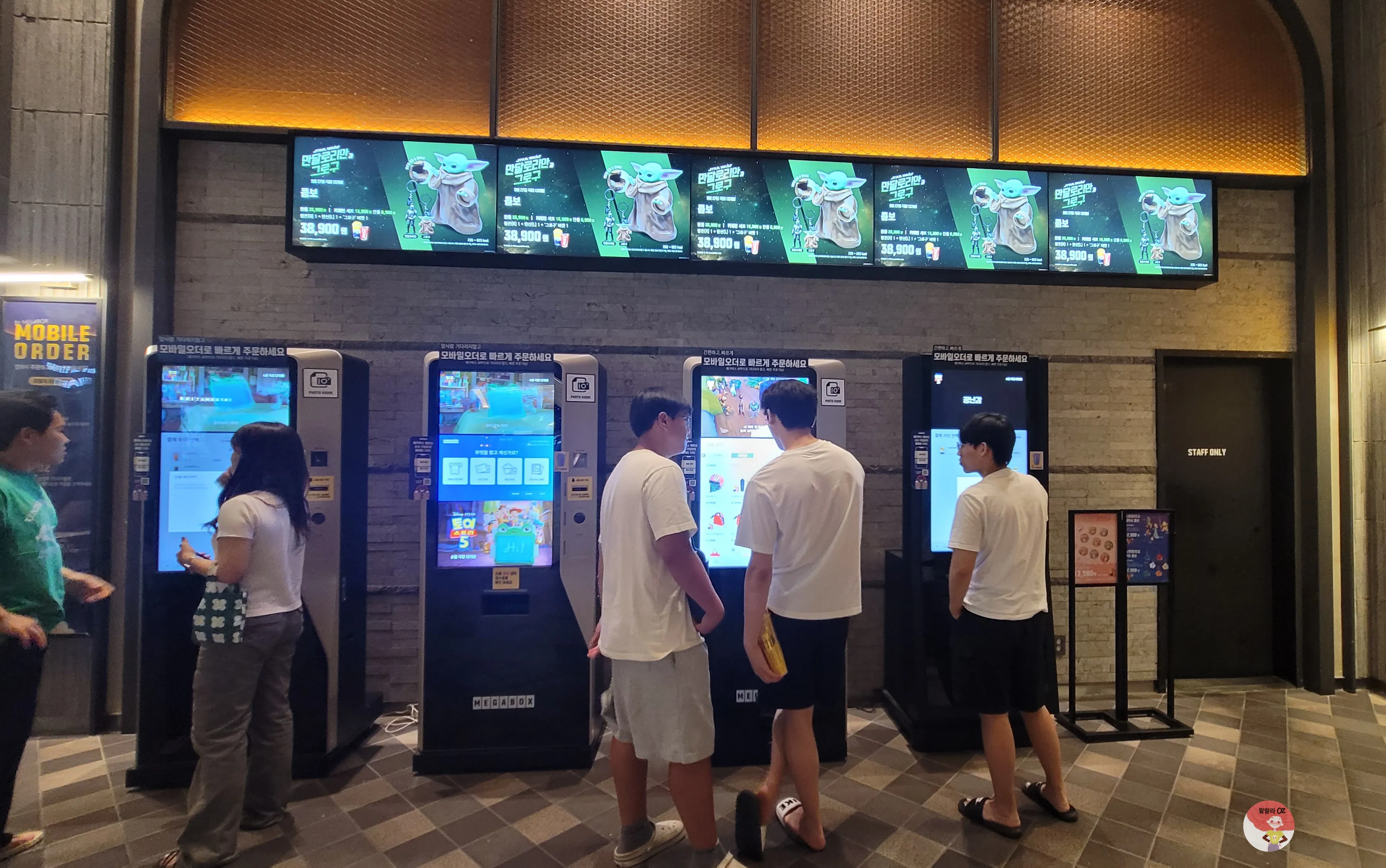 다산아울렛 메가박스 내부, 여러 명이 영화 티켓 발권 키오스크에서 예매를 하는 모습
