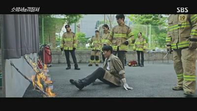 말아 놓은 신문지에 불을 붙이는 김래원 사진 입니다.