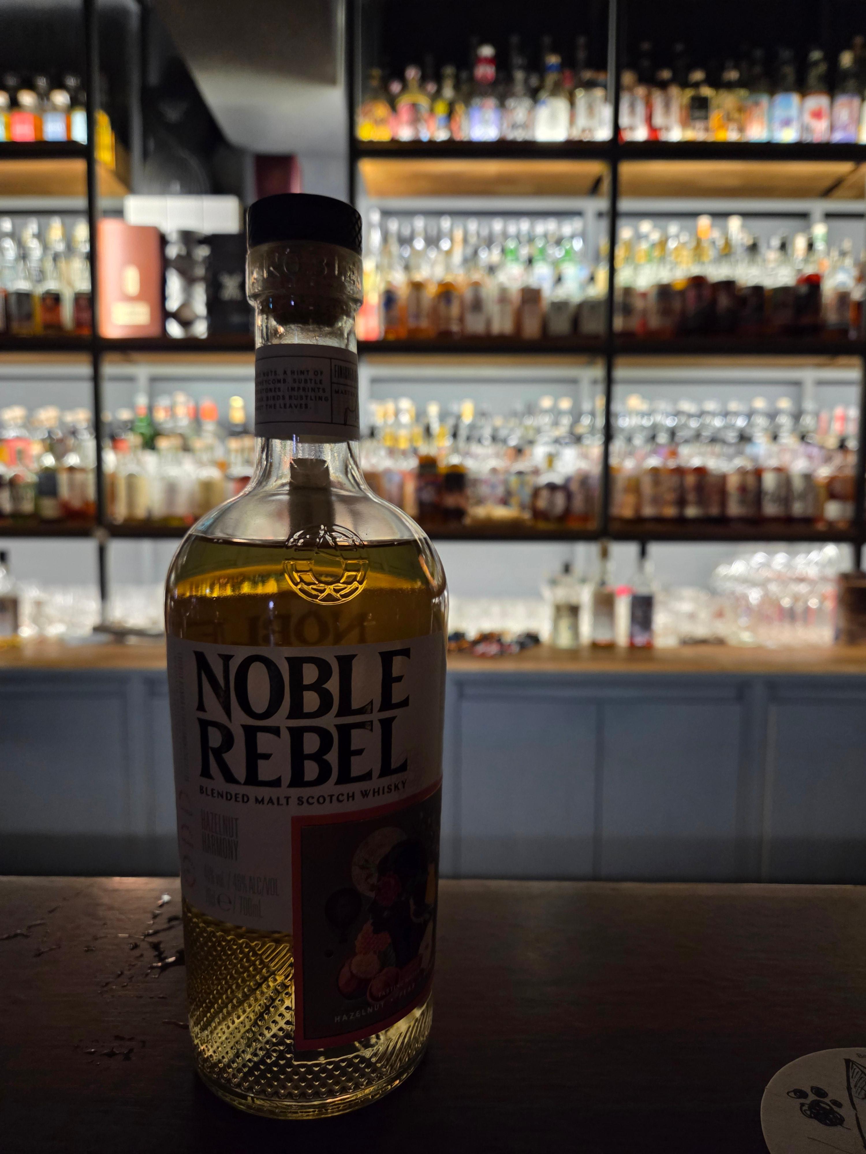 바밤 카운터 위에 놓인 노블 레벨(Noble Rebel) 위스키 잔과 병