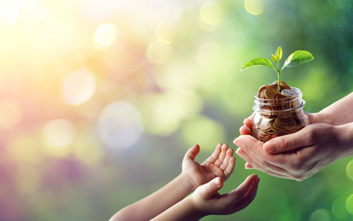 동전이 가득찬 유리병을 건네고 있는 손