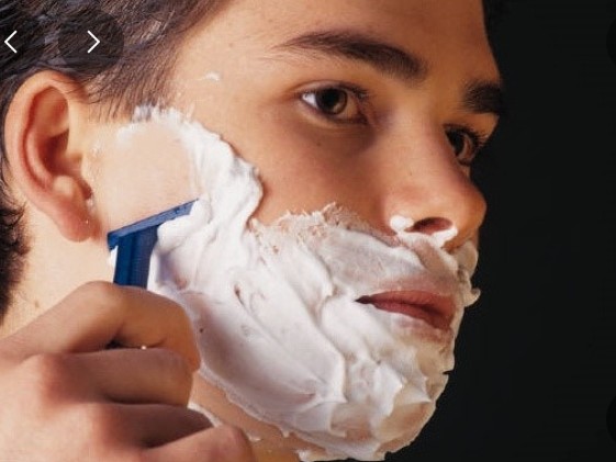 신중히 면도하는 남성