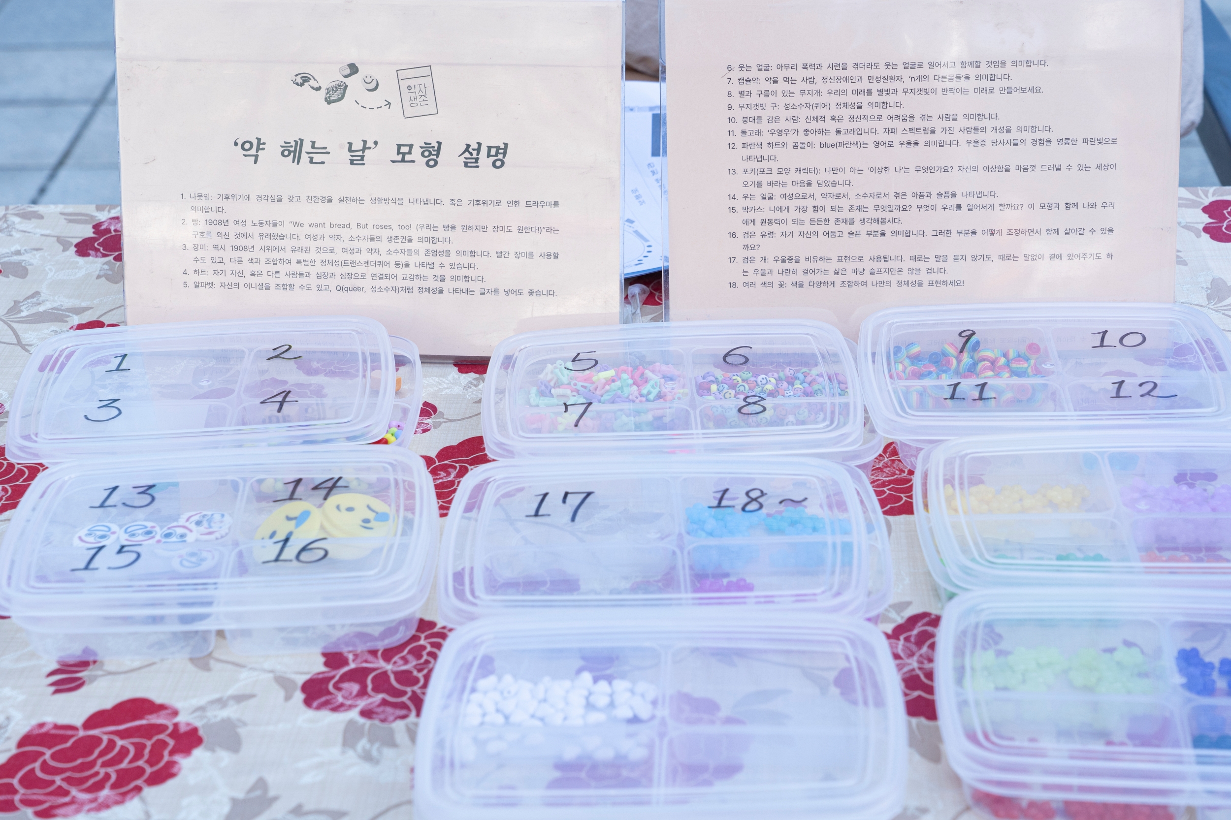 &lt;약 헤는 날&gt; 모형 설명서가 테이블에 세워져 있고&#44; 그 밑으로 모형들이 숫자가 적힌 투명 수납함에 들어 있다.