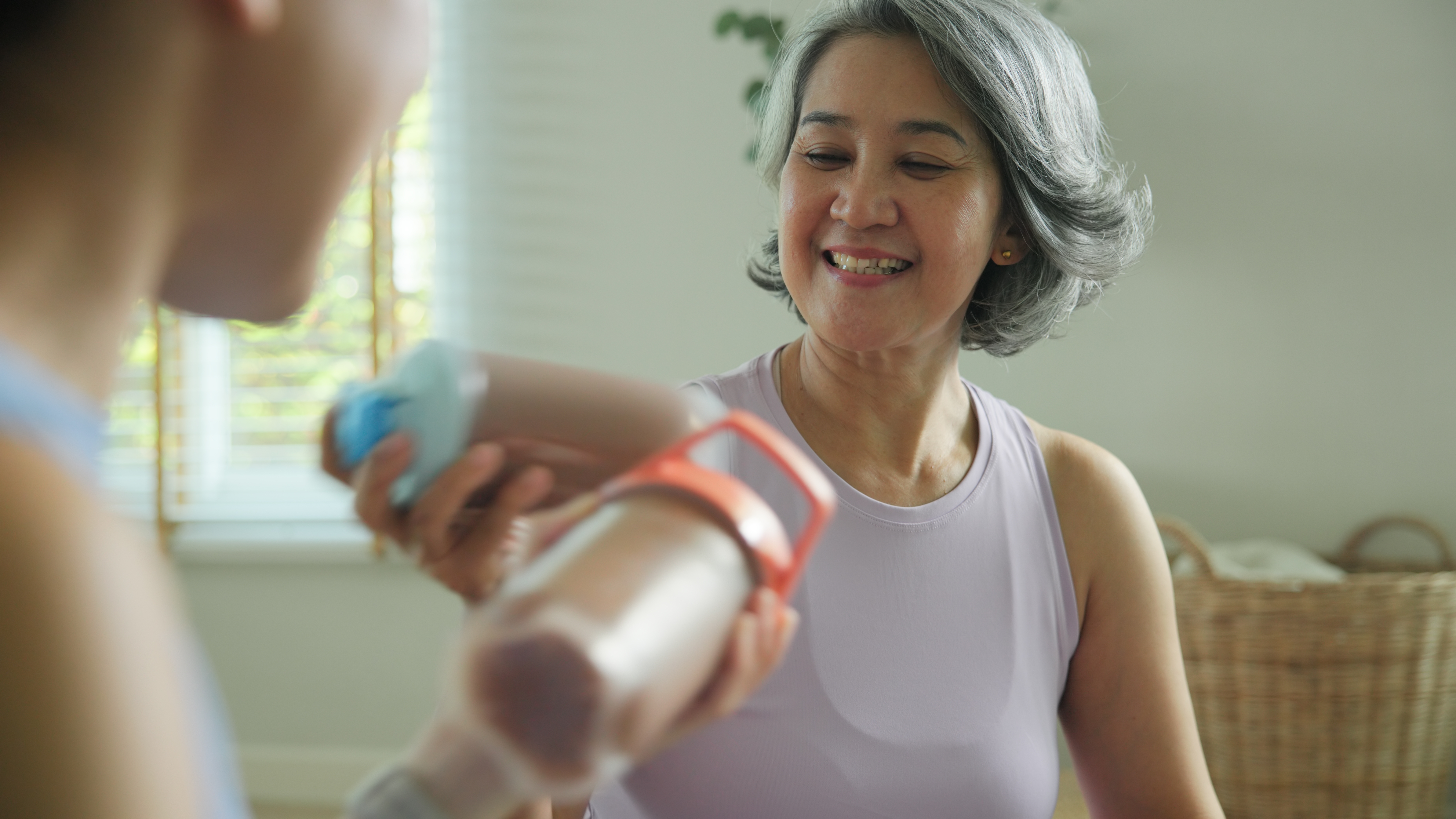 운동 후 단백질 쉐이크를 나누며 웃고 있는 중년 여성 – 실패 후에도 긍정적으로 다시 시작하는 건강한 일상