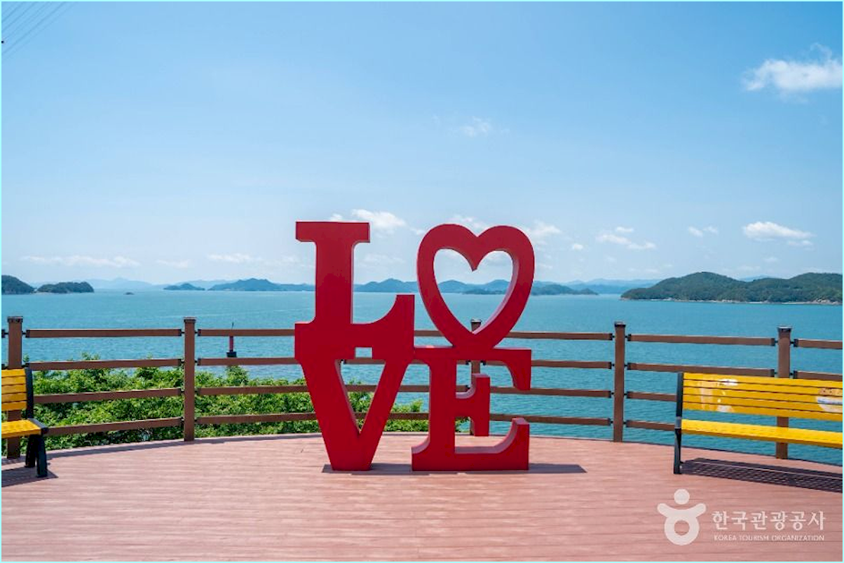 푸른 바다를 배경으로 서 있는 빨간색 LOVE 조형물