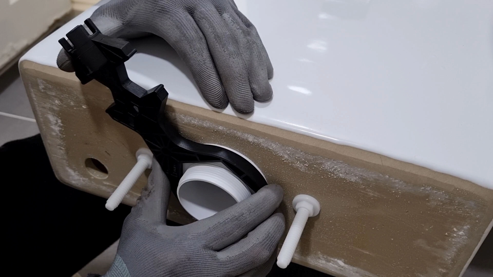 변기 물탱크 부속 고정하는 모습