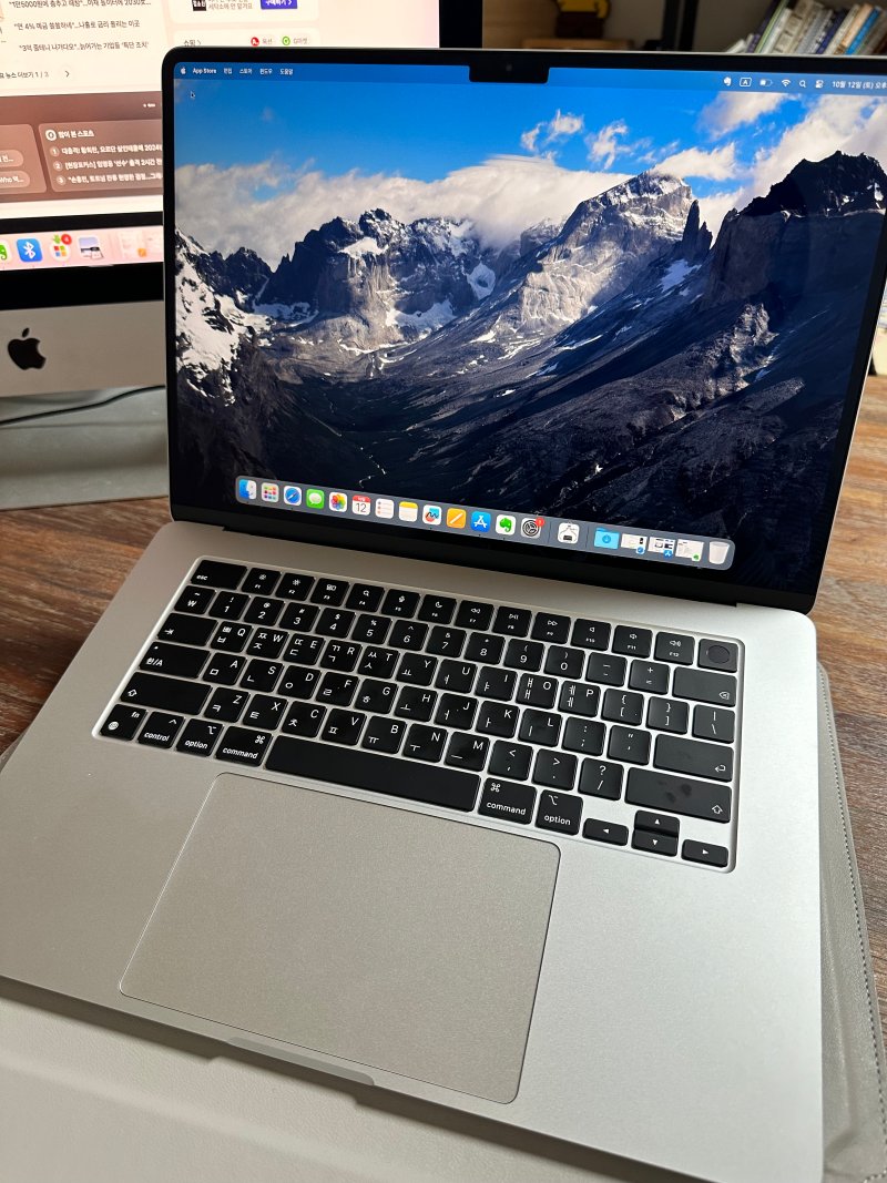 맥북에어 15인치가 펼쳐져 있는 모습으로 화면에서 겨울 산의 사진이 보인다