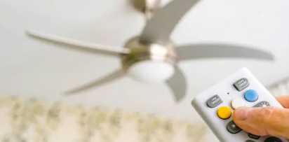 실링팬을 향해 리모콘으로 조정하는 사람손