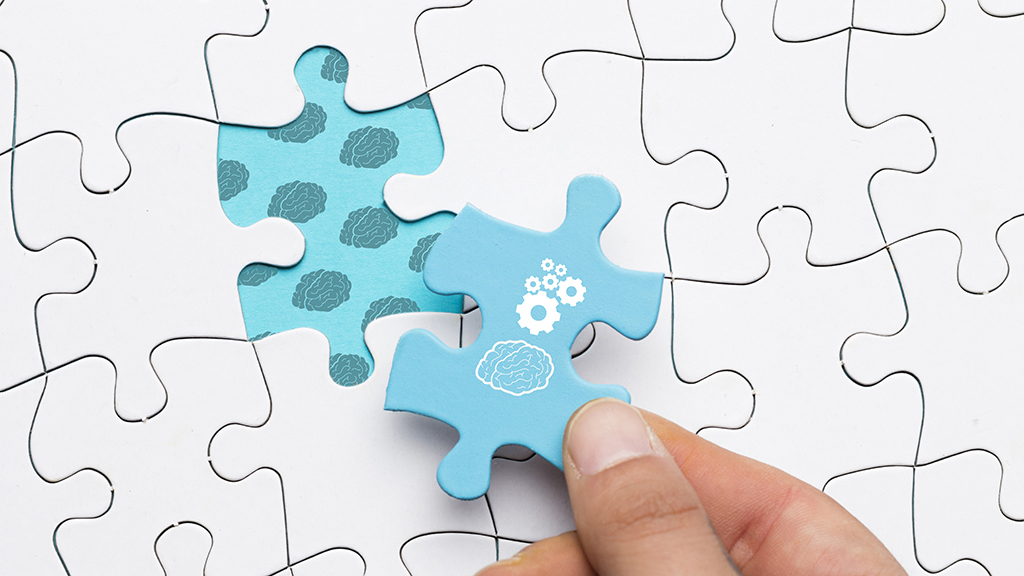 흰 바탕에 인간의 뇌와 톱니바퀴가 그려진 파란색 퍼즐 조각
