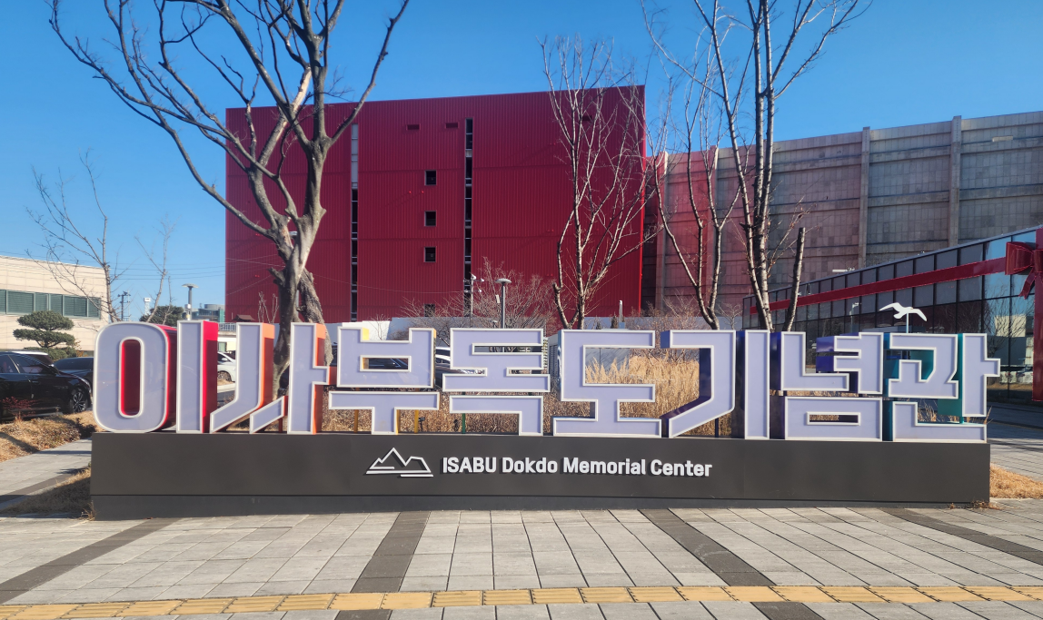이사부 독도기념관 대형 간판과 붉은 외관 건물이 함께 보이는 전면 풍경