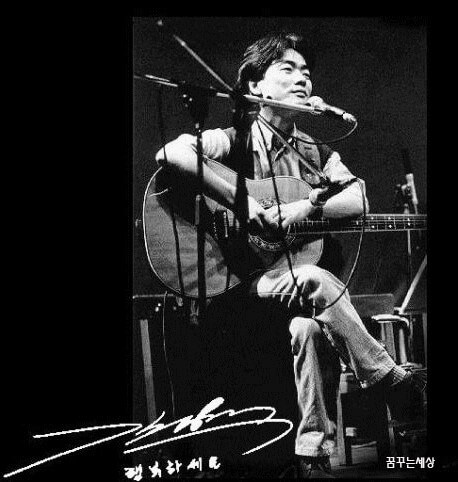 김광석-나의-노래-악보-김광석이-무대-위에-앉아-기타를-연주하고-있는-사진-왼쪽-아래에-그의-사인이-있다.