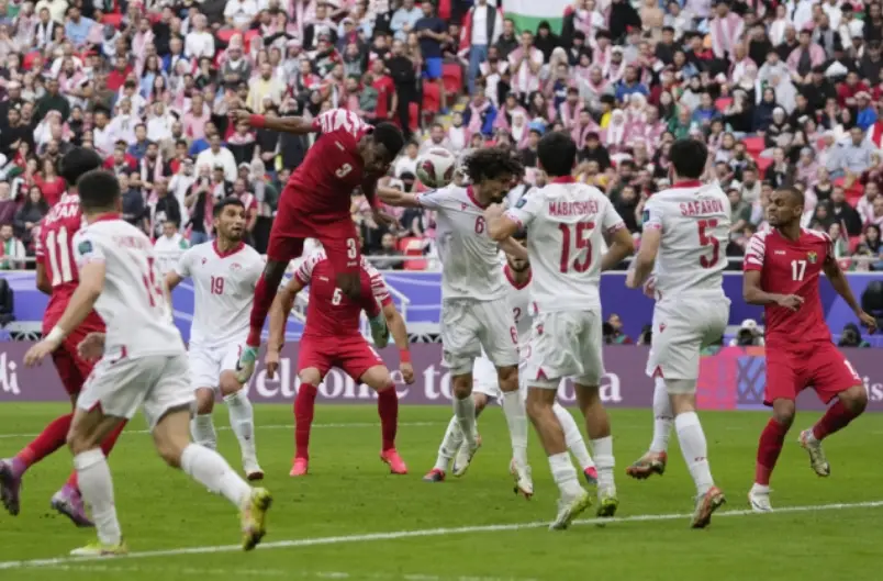 호주전- 붉은옷을 입은 요르단 선수가 헤딩을 하고 흰옷을 입운 선수들이 그를 막고 있는 모습