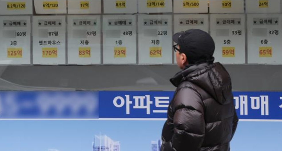 중개사무소 앞에 서서 물건을 보는 남성