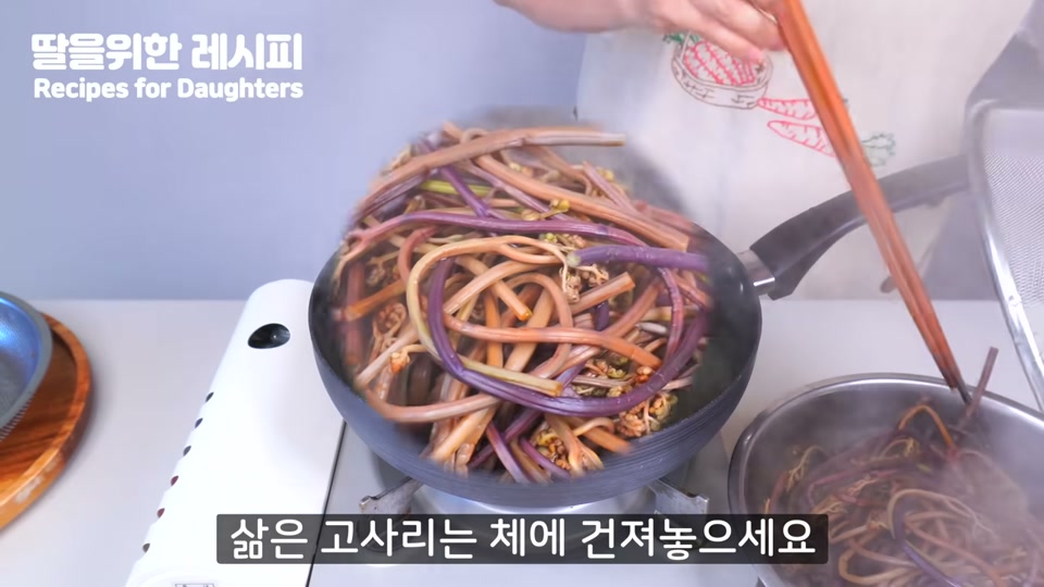 삶은 고사리를 체에 건지는 장면