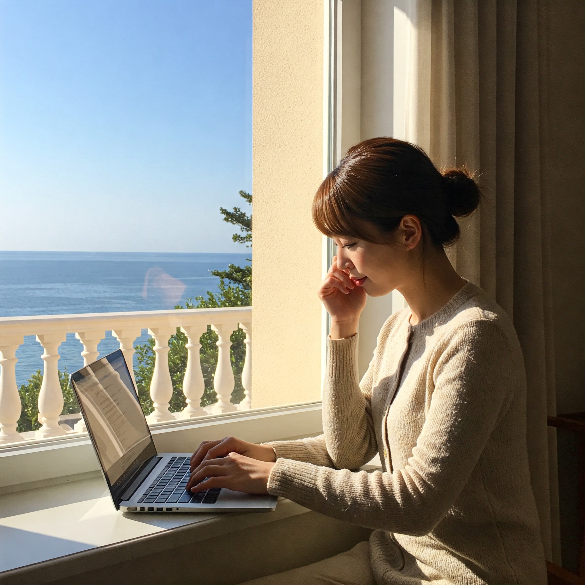 바다가 보이는 창가에서 노트북 하는 여자
