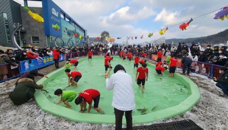 커다랗고 둥근 수영장 처럼 생긴 곳에 빙어를 풀어놓고 짤은 반팔티에 반바지를 입은 관광객들이 맨손으로 송어를 잡기위해 이리저리 분주한 모습