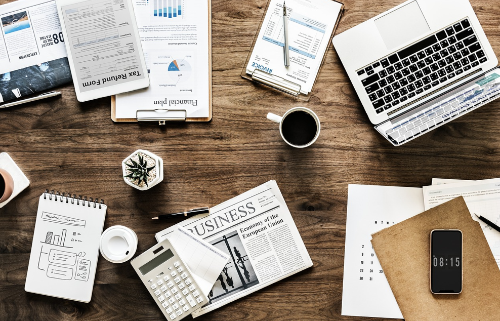 책상위에 노트북, 신문, 패드등 자료 수집하는 모습