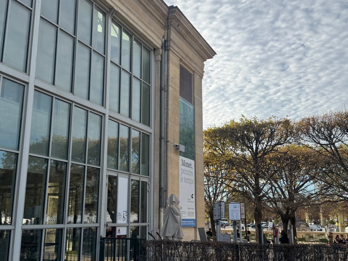 Musée de l'Orangerie exterior building and Monet exhibition banner under autumn sky in Paris.
