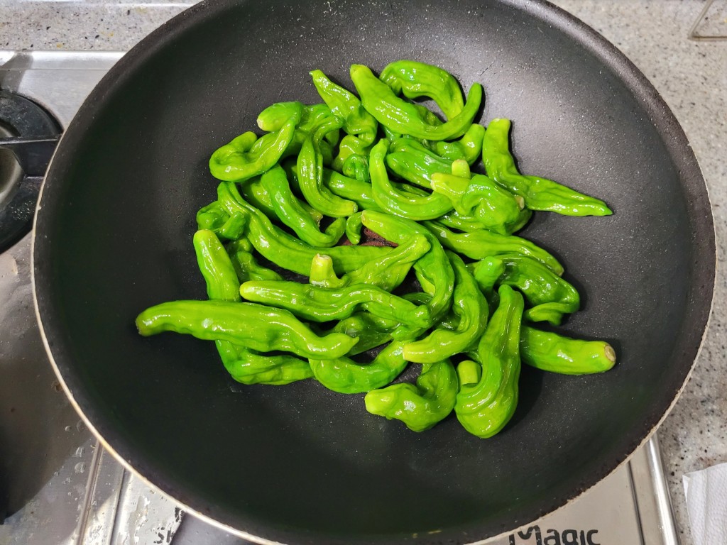 기름을 두르고 꽈리고추를 먼저 볶는 장면