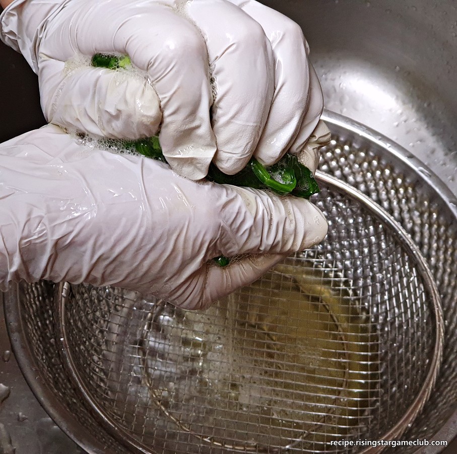 시금치나물 무침을 하기 위해서 데쳐진 시금치를 두손으로 잡고 물기를 짜는 사진