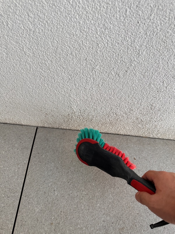 브러시로 심한 부위의 벽면을 문지르고 있습니다.