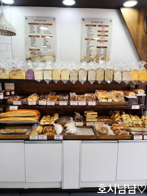 하남 인디오븐 빵집 진열대 &ndash; 식빵, 바게트, 크로와상, 머핀 등 다양한 빵이 가지런히 놓인 모습