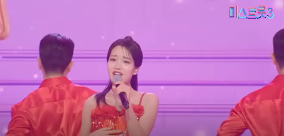 미스트롯3- 보라색 무대 빨간 와이셔츠를 입은 백댄서사이에서 빨간 옷을 입고 왼손으로 마이크를 든채 노래하는 김소연