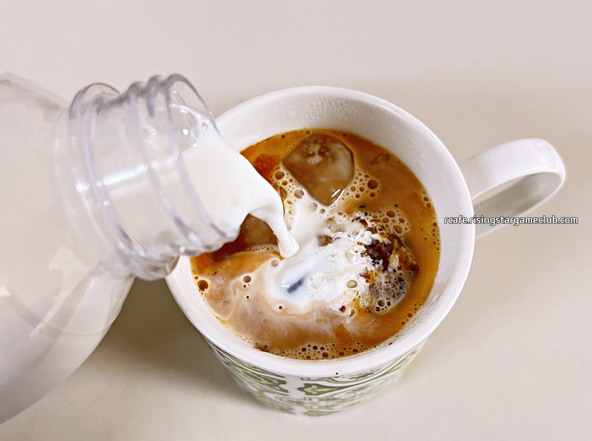 카페라떼를 만들기 위해 커피에 우유를 붓고 있는 사진