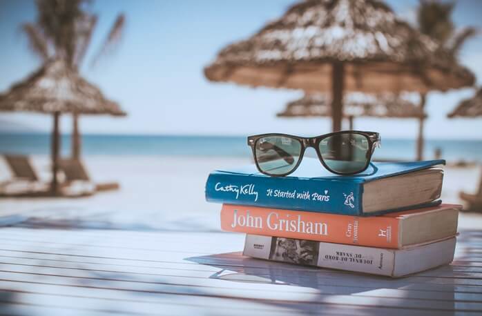 책 세 권 위에 놓여있는 갈색테의 썬글라스