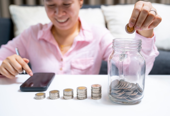 한 여자가 동전을 유리병에 넣는 모습