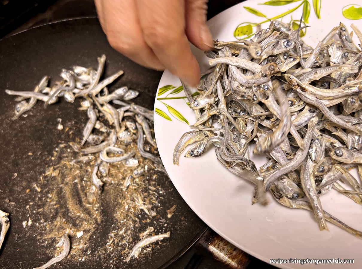 잘 덖어진 멸치를 접시에 옮겨 담는 사진