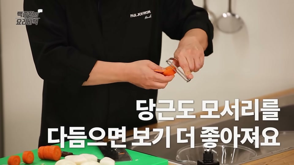 당근 모서리를 감자칼로 다듬는 장면