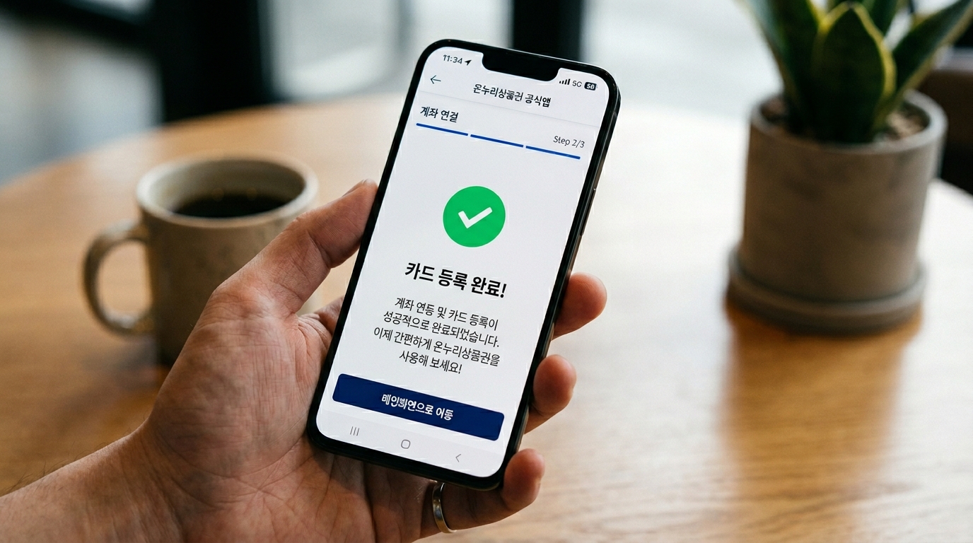 공식 온누리상품권 앱이 설치된 스마트폰 화면에서 사용자가 자신의 계좌를 연동하고 카드 등록을 완료하는 모바일 인터페이스 화면