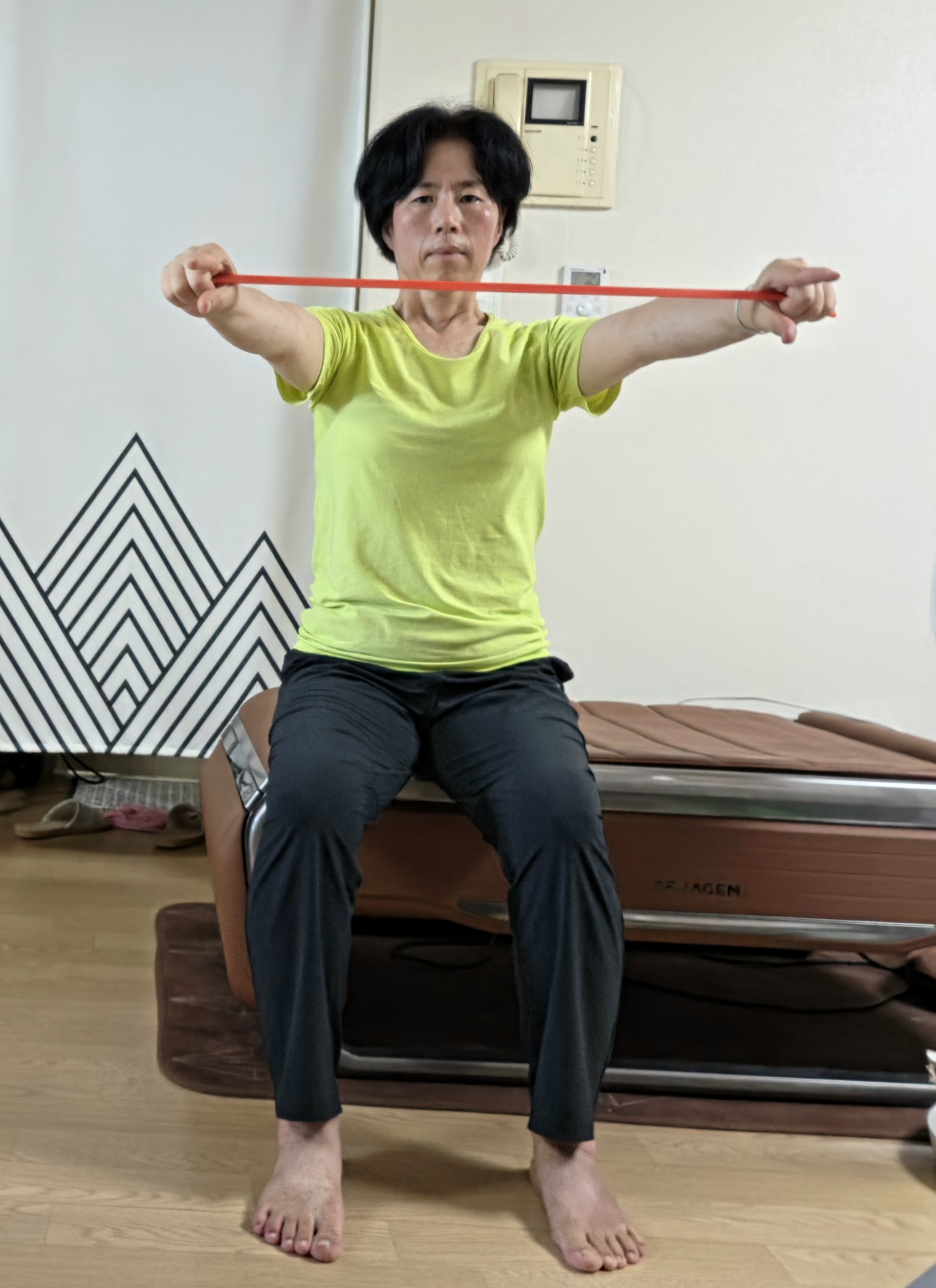 밴드로 회전근개와 날개뼈 보강 운동을 하는 모습