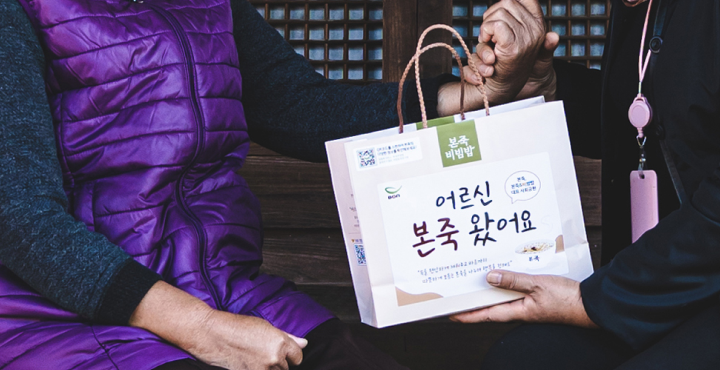 죽이 담긴 종이 가방을 할머니에게 건내는 아들