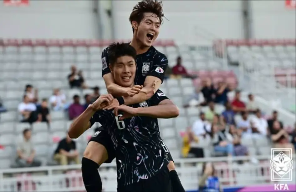 u23-축구그라운드에서 검은 유니폼을 입고 상대선수를 뛰어안아 껴안는 모습
