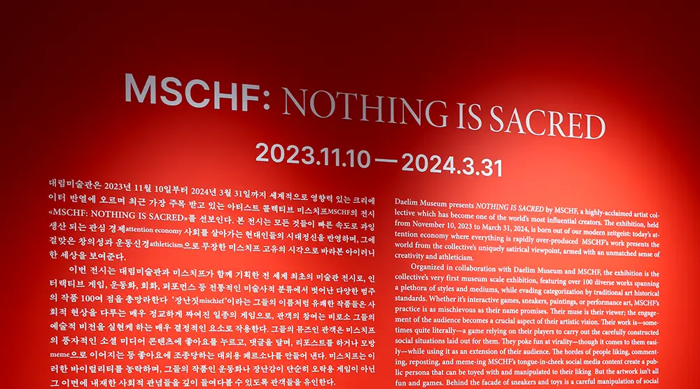 강렬한-빨란-벽에-흰색으로-적혀-있는-전시-슬로건-및-소개글