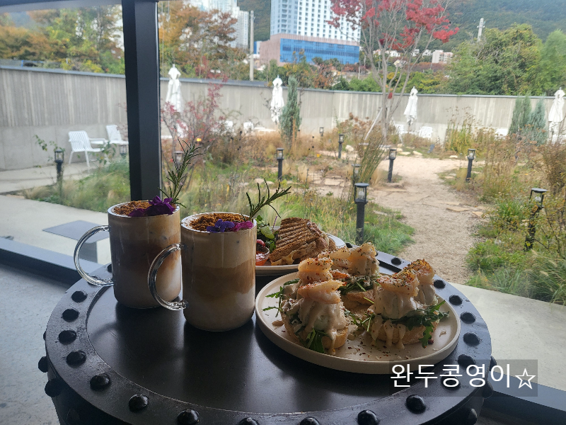 거제 지세포 인더하버스 테이블에 앉아 보이는 창가 너머 작은정원