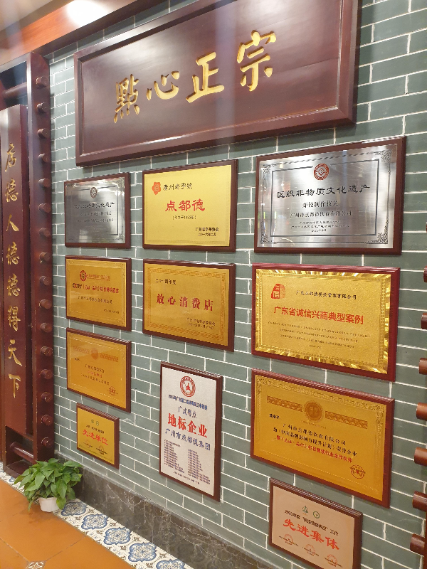 초록색 타일 위에 각종 인증서들이 전시되어 있다.