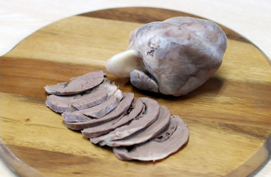 돼지의 심장을 잘 삶아서 동그란 나무 깔판 위에 하나를 두고 하나는 편으로 썰어서 가지런히 두고 찍은 사진