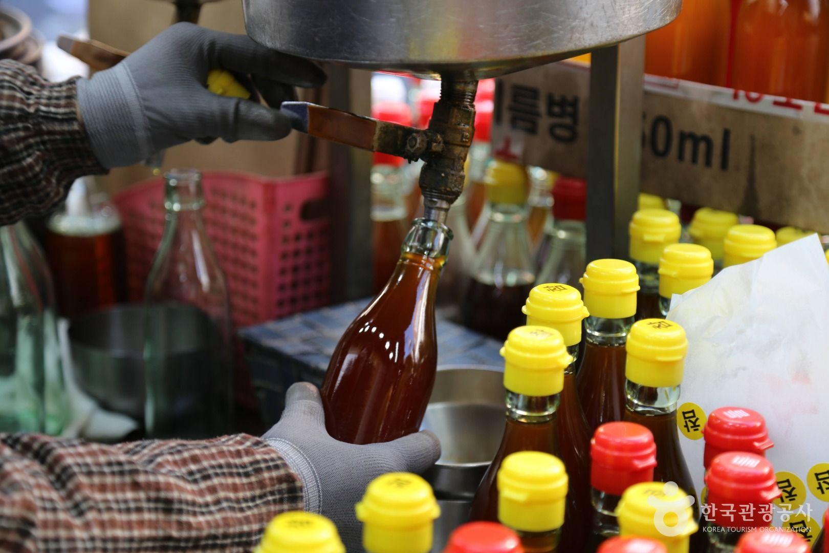모란민속시장. 갓 짠 고소한 참기름을 담는 모습