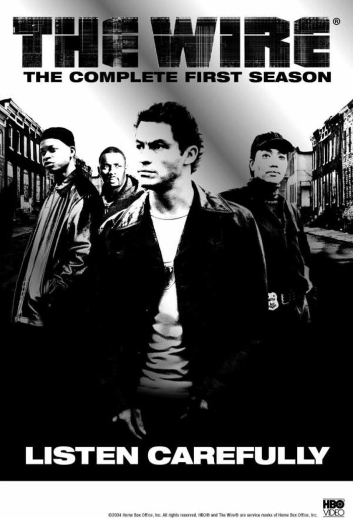 "HBO 드라마 '더 와이어' 시즌1 공식 포스터. 흑백 이미지 속 형사와 범죄자들이 등장하며, 배경은 황폐한 도시 거리. 'LISTEN CAREFULLY'라는 문구가 강조되어 있으며, 범죄와 수사 스토리를 암시하는 분위기를 담고 있다."