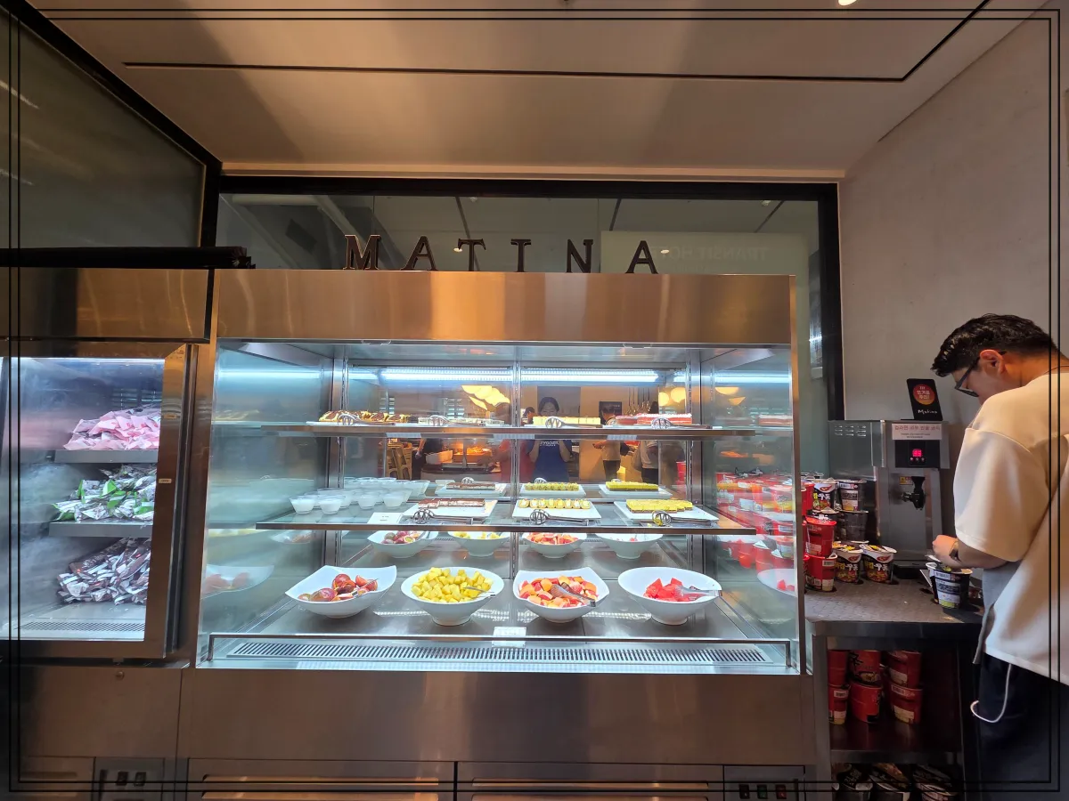 유리-진열장-안에는-조각케이크와-과일-푸딩이-진열되어-있고-오른쪽에는-컵라면과-온수기가-보임