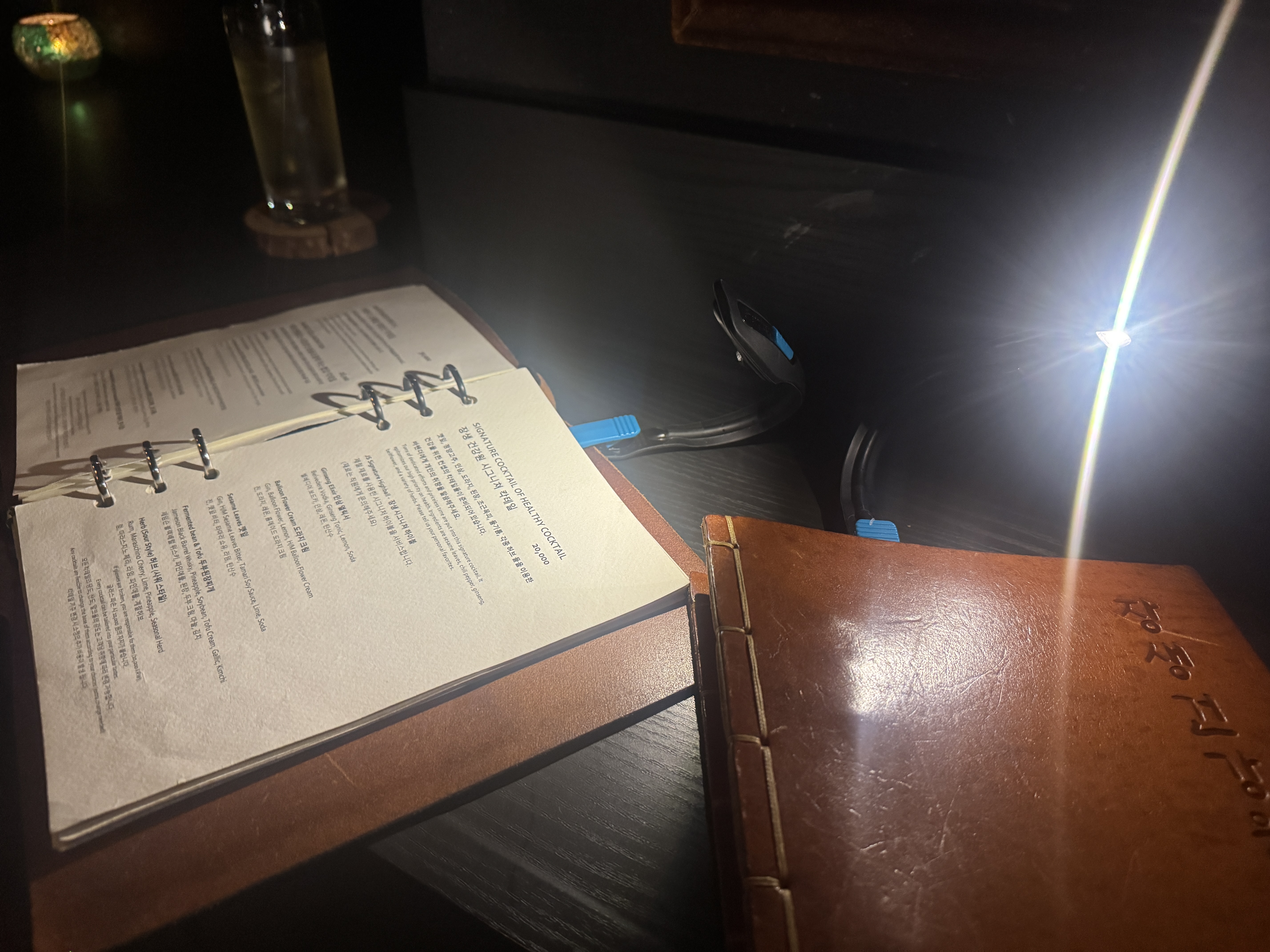 장생건강원 메뉴판 외관과 분위기. 가죽 커버와 메뉴판 위에 달린 조명이 어우러진 전경