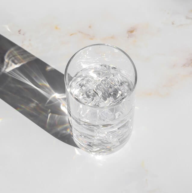 빛을 받아 반짝이는 얼음물이 든 컵 사진